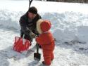 Папа с дочей убирают снег